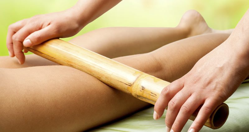 Experience tranquil healing with a hands-free bamboo stick massage, promoting holistic wellness for the woman.