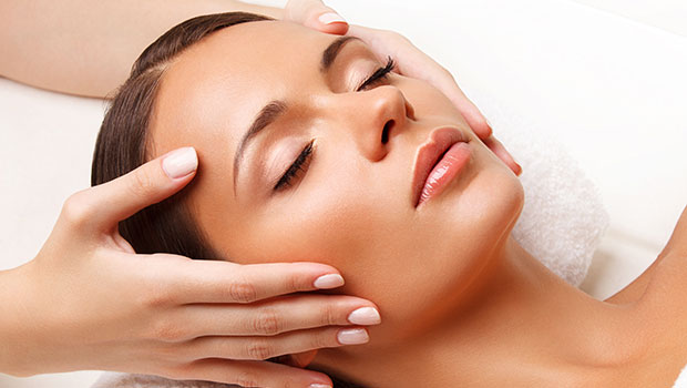 A woman experiencing a tranquil facial massage at a spa, promoting mind-body harmony.