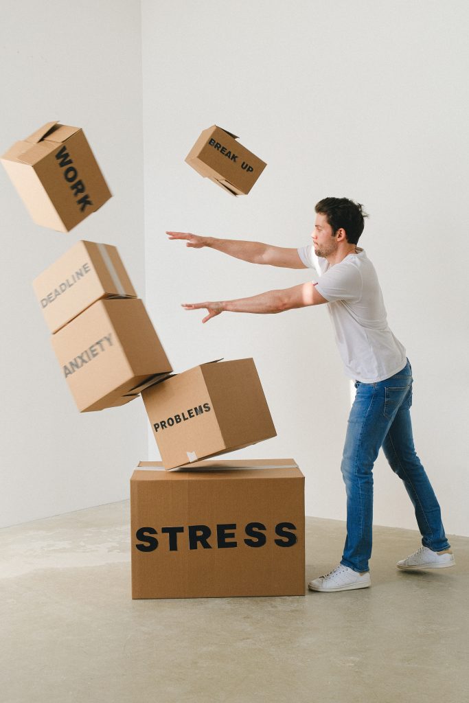 A man is throwing boxes with the word stress, promoting Holistic Wellness and Tranquil Healing.
