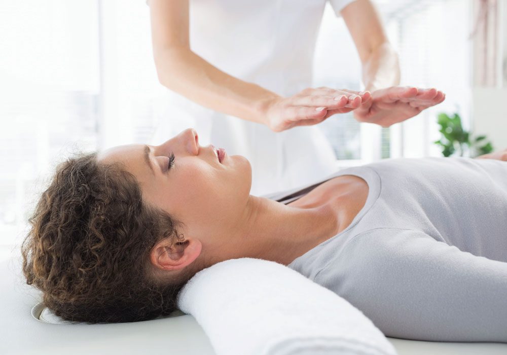 Ar Holistic Therapy - Bradford - A woman is experiencing the transformative power of touch as she receives a massage from a therapist.