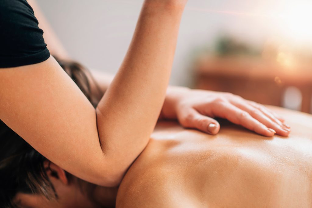 Ar Holistic Therapy - Bradford - A woman experiencing the power of touch through a relaxing back massage at a spa.