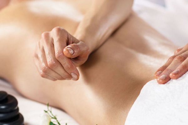 Ar Holistic Therapy - Bradford - Experience the power of touch as a woman enjoys a soothing back massage at a serene spa.