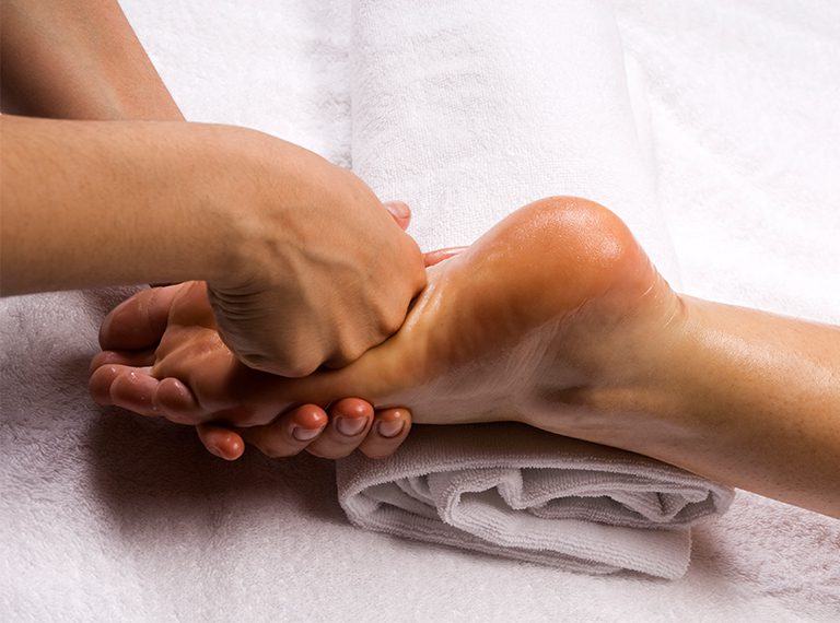 Ar Holistic Therapy - Bradford - Experience the power of touch as a woman indulges in a blissful foot massage at a spa.