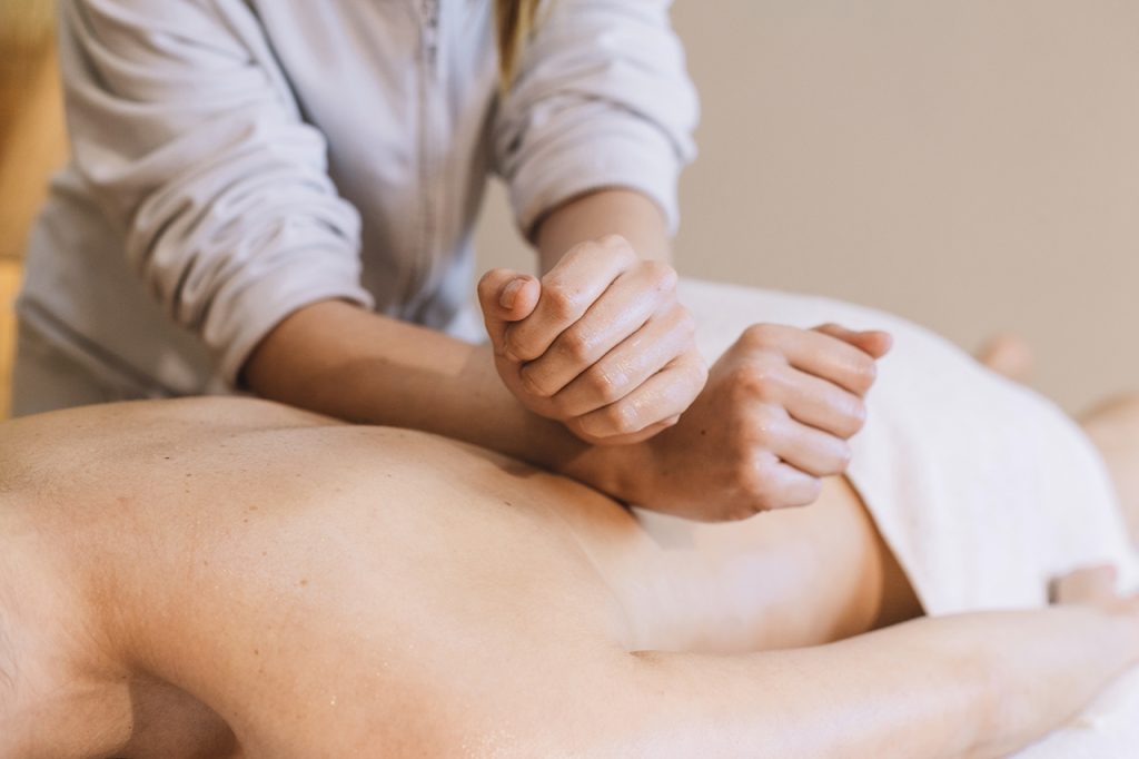 Ar Holistic Therapy - Bradford - A woman experiencing the power of touch during a relaxing massage at a spa.