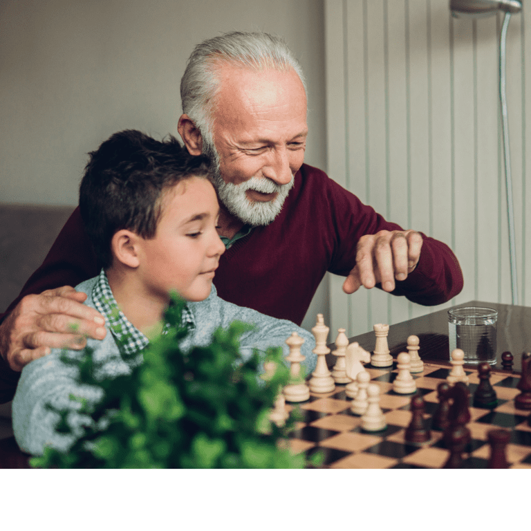 Ar Holistic Therapy - Bradford - An older man and a young boy engage in a game of chess, fostering a connection that aids in healing the boy's inner child.
