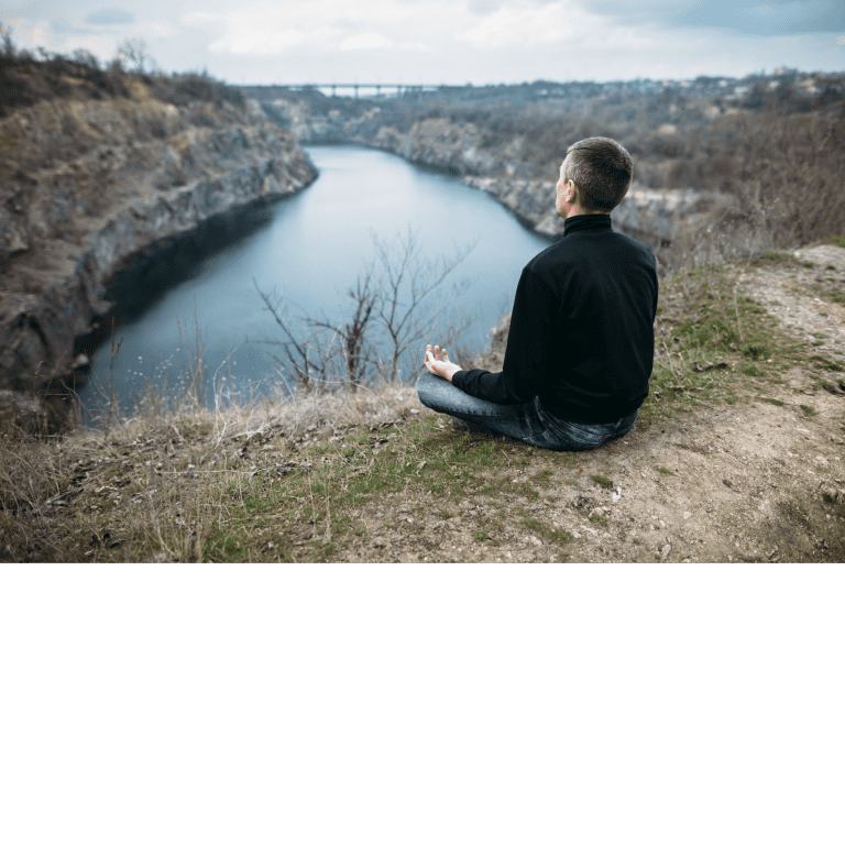 Ar Holistic Therapy - Bradford - A man achieving peak performance meditating on a hill overlooking a river.