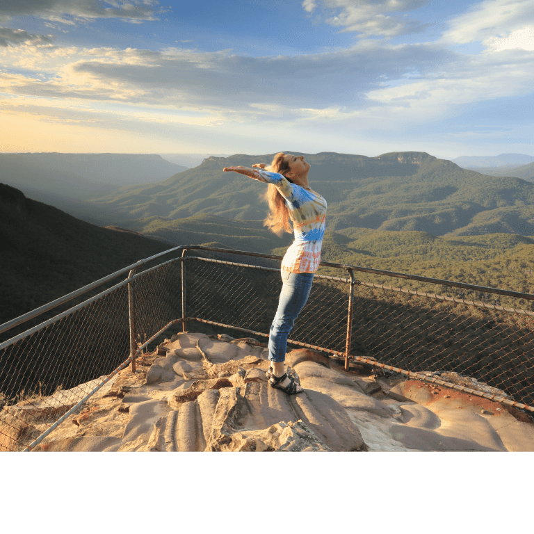 Ar Holistic Therapy - Bradford - A woman standing on top of a mountain, affirming her connection with the blue mountains.
