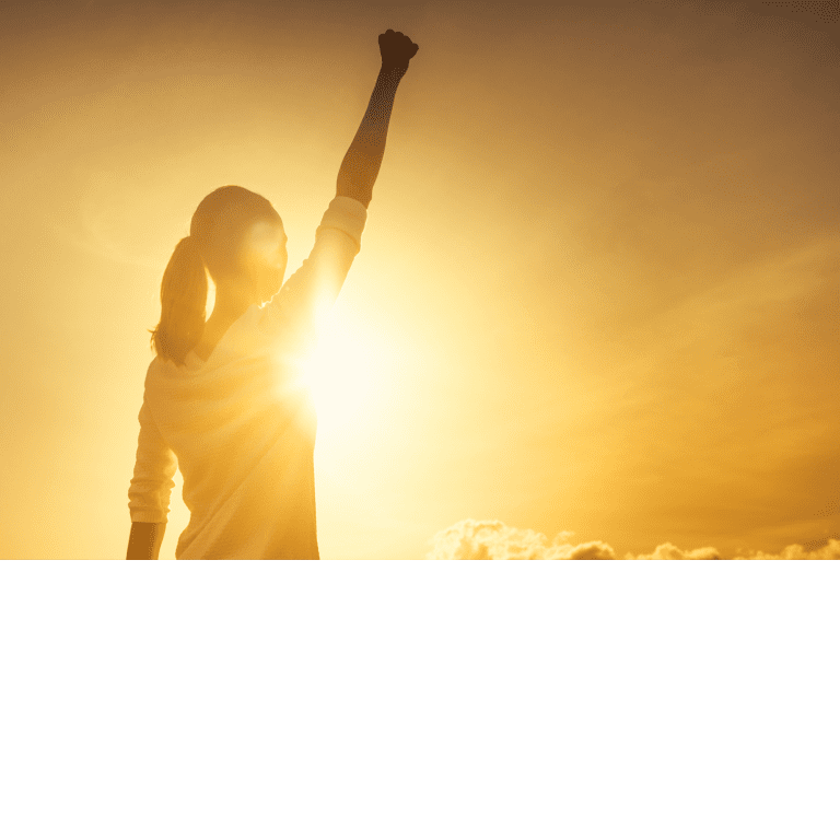 Ar Holistic Therapy - Bradford - A powerful woman raising her fist in the air at sunset, embodying the strength of willpower.