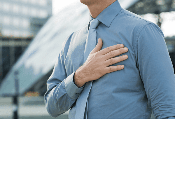 Ar Holistic Therapy - Bradford - A man showing signs of discomfort while clutching his chest in front of a building.