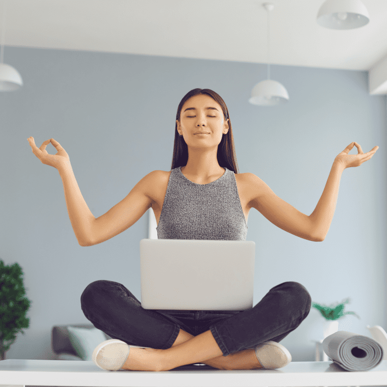 Ar Holistic Therapy - Bradford - A woman cultivating a positive mindset while meditating with a laptop at home.