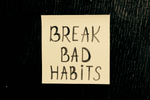 Ar Holistic Therapy - Bradford - Sticky note with the message "break bad habits" handwritten on it, posted on a dark textured background.
